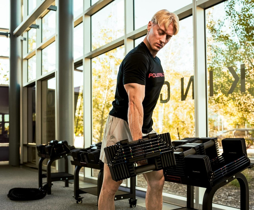 Man racking commercial pro 125 dumbbells on stand