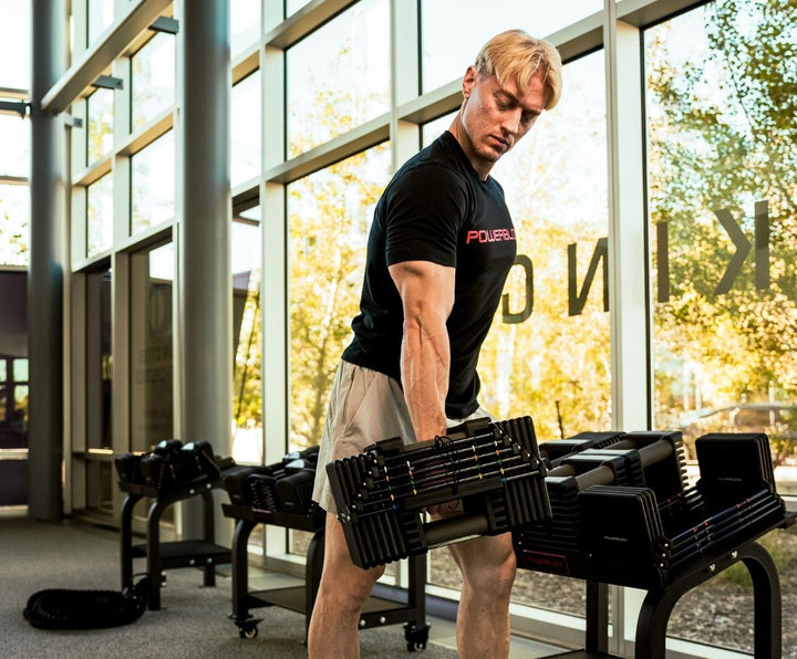 Man racking commercial pro 125 dumbbells on stand