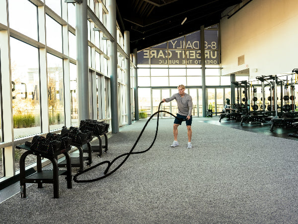 Person using PowerBlock Battle Rope at the gym.