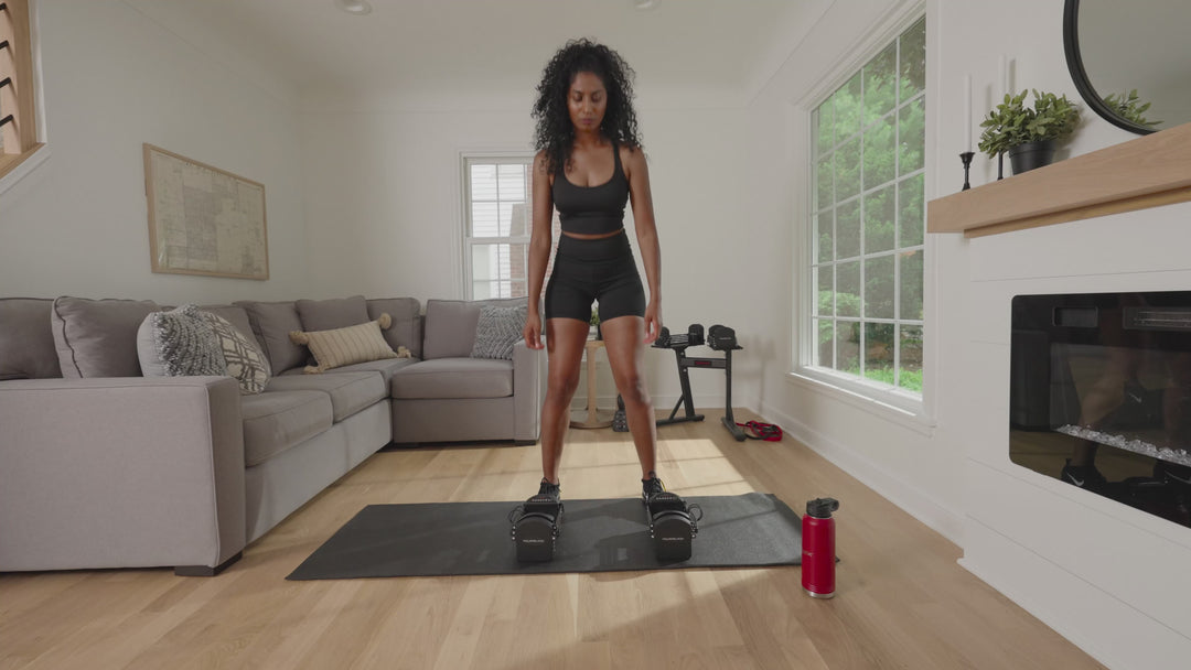Woman using a pair of PowerBlock Pro 32 adjustable dumbbells .