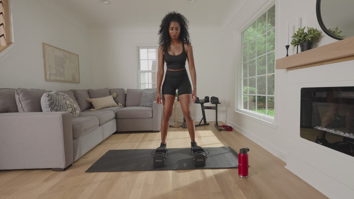 Woman using a pair of PowerBlock Pro 32 adjustable dumbbells .