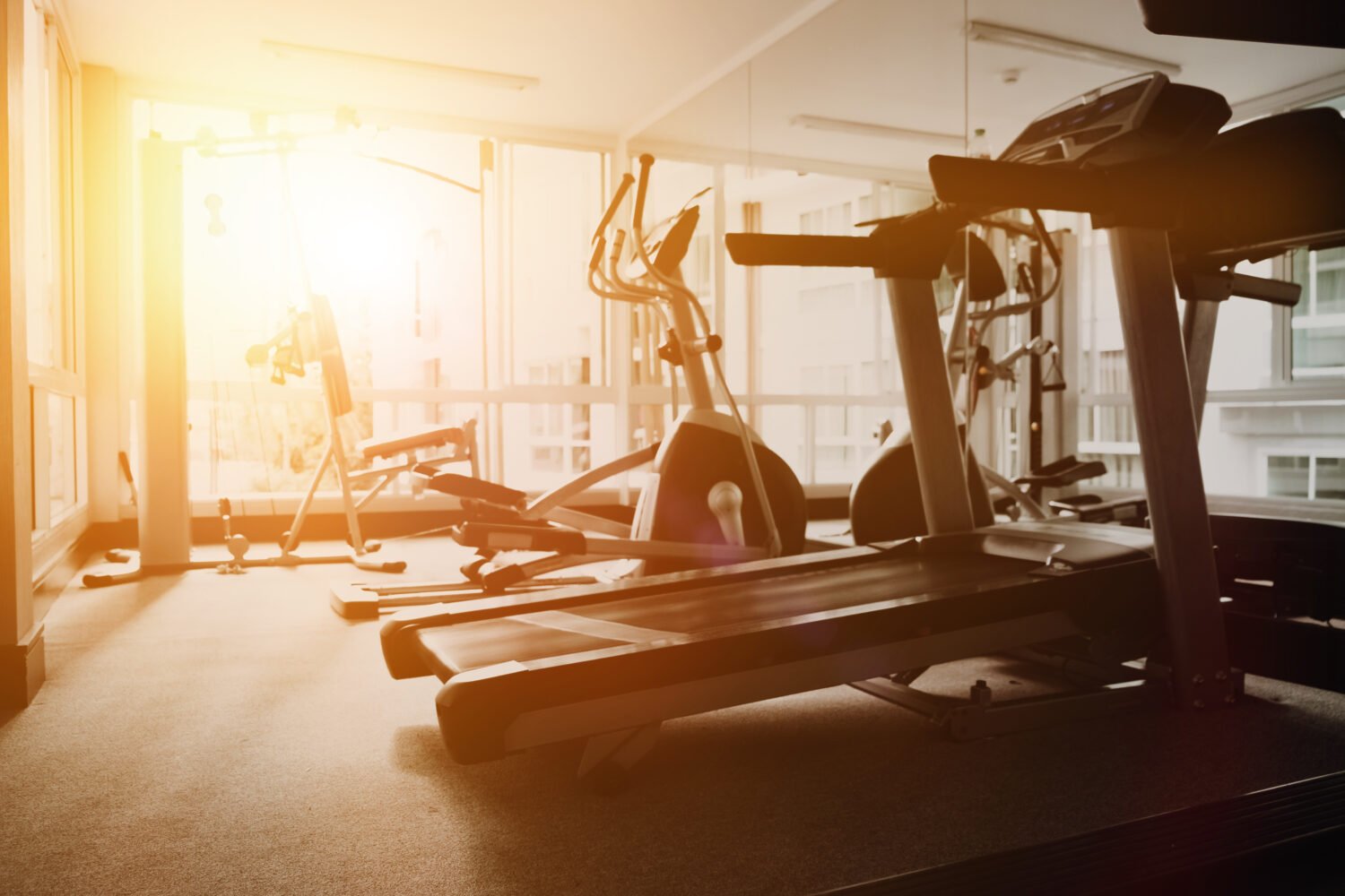 an office gym at sunrise with treadmills and other gym equipment