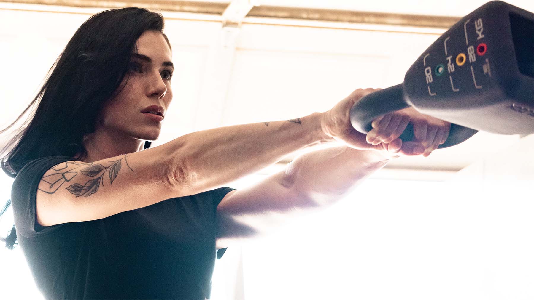 Female athlete performing kettlebell swing for a full body adjustable kettlebell workout