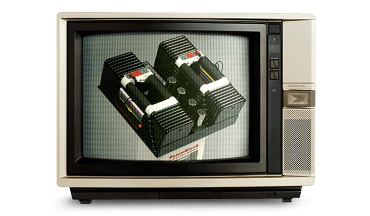 A vintage 90's television showing an image of two "The PowerBlock" model dumbbells