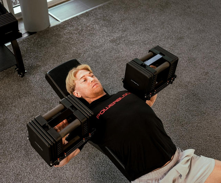 Man lifting Commercial Pro 175 Dumbbells on PowerBench 