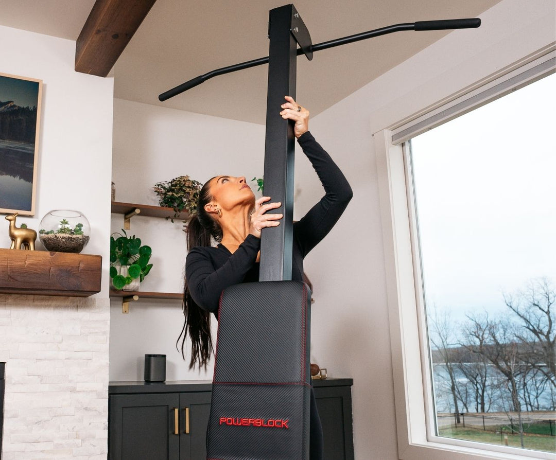 Woman setting up the powerbench 2.0 chin-up attachment