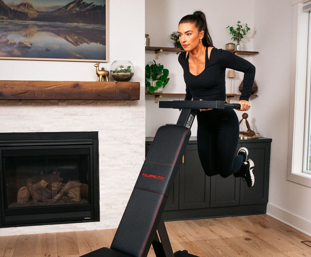 Woman exercising using the PowerBench 2.0 dip attachment