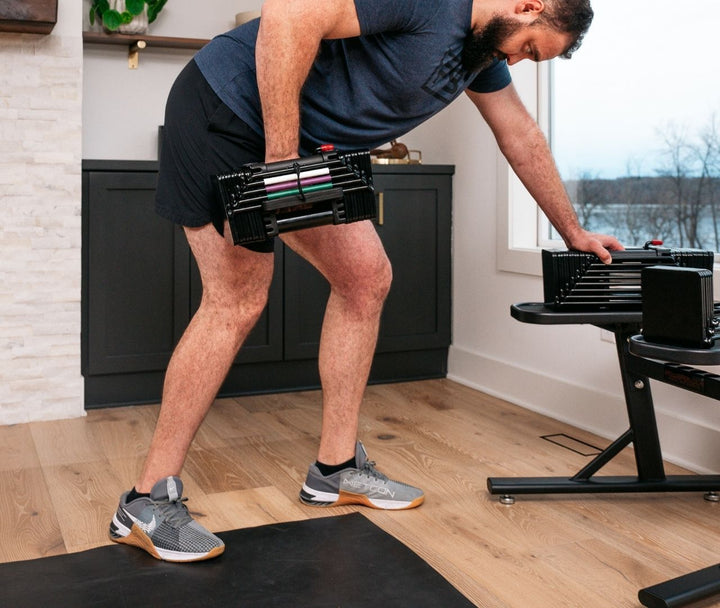Man lifting Elite USA Dumbbells from PowerMax 2.0 Stsnd