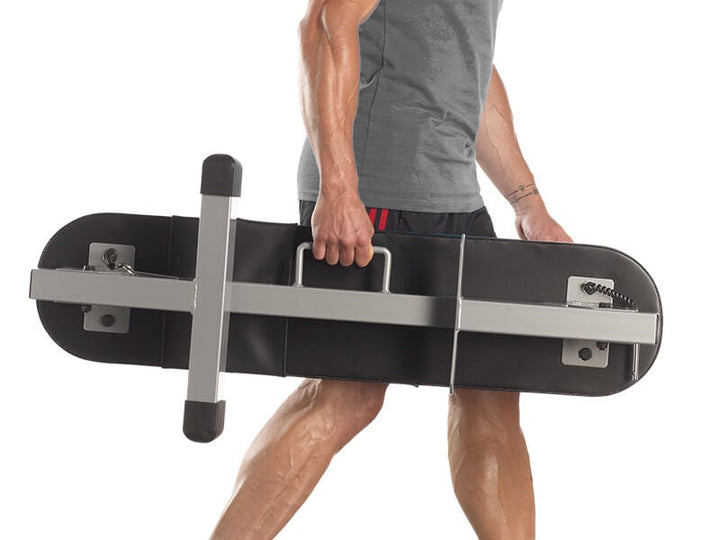 Man showing how easy it is to carry the PowerBlock Portable Weight Bench.