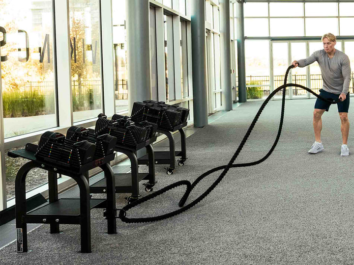 Man using a powerblock battle rope with stand attachment anchor in a commercial gym