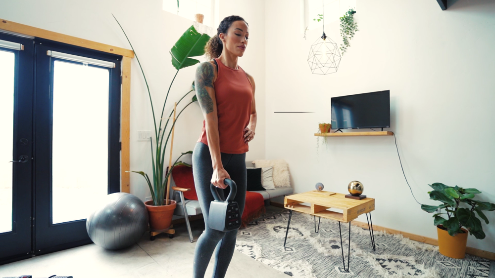 A woman doing single-leg deadlifts with a PowerBlock adjustable kettlebell