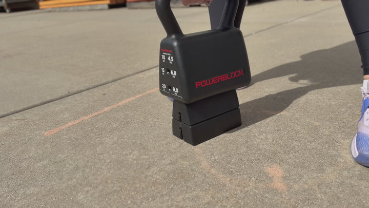 Woman using the PowerBlock Sport Kettlebell doing swing excercises and changing weights.