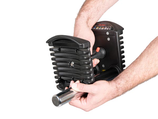 Person removing cylindrical 2.5 pound micro weights from PowerBlock Pro 50 adjustable dumbbell handle.