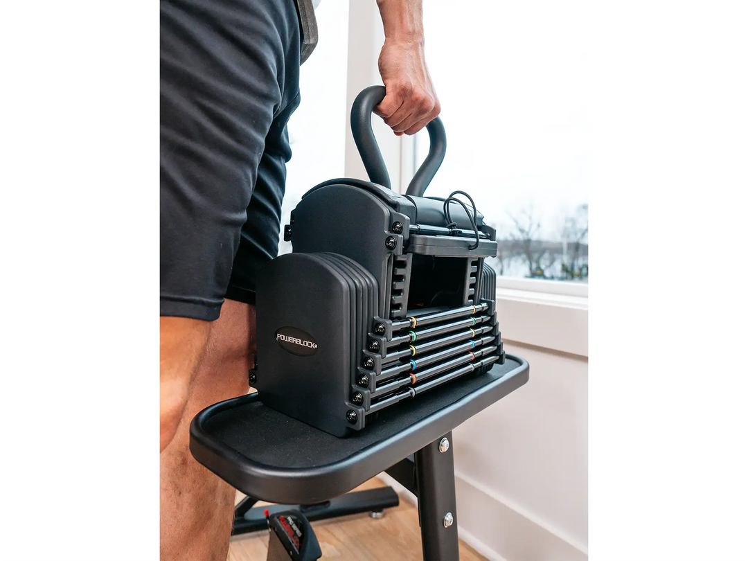 Athlete lifts the pro 50 adjustable dumbbell with the pro series kettlebell in the handle.