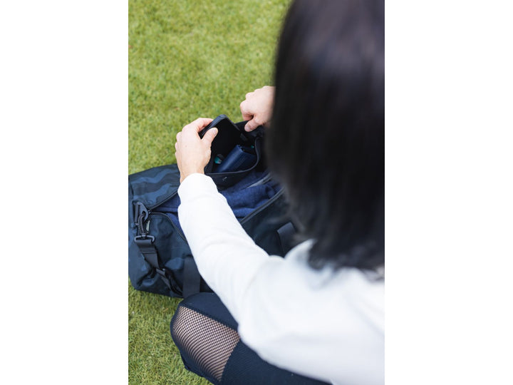 Woman pulling item out of black PowerBlock Duffle Bag.