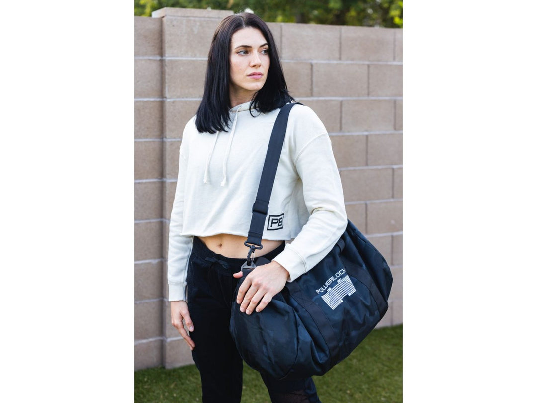 Woman carrying black PowerBlock Duffle Bag on her shoulder.