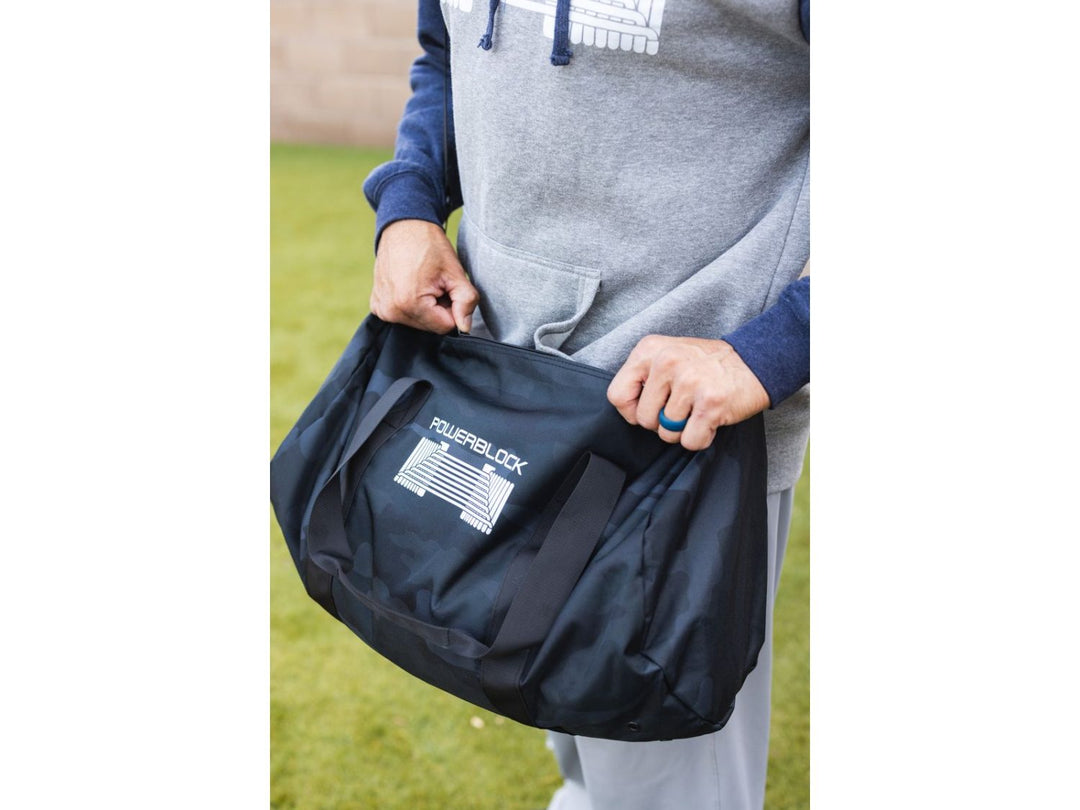 Man holding black Duffle Bag on PowerBlock logo side.