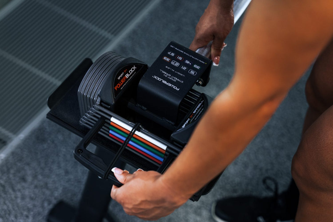 Woman using the Magnetic Selector Pin to change the weight while using the Sport 24 Straight Bar.