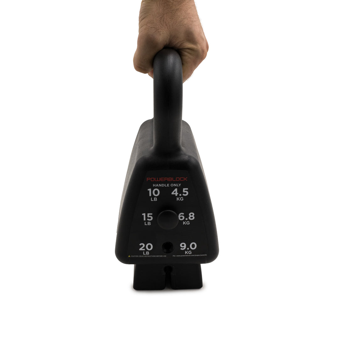 A hand holding the handle of the black PowerBlock kettlebell lifting the 15 lbs up 