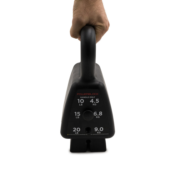 A hand holding the handle of the black PowerBlock kettlebell lifting the 15 lbs up 