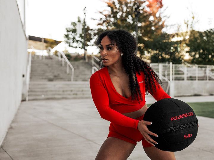 fit woman preparing to throw a wall ball at a concrete wall