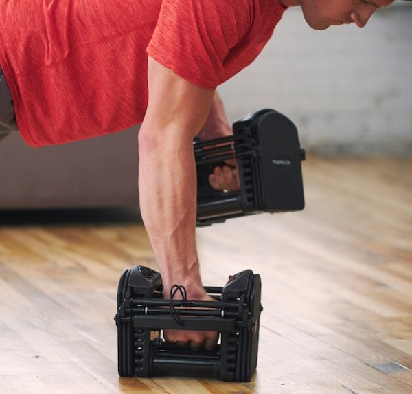 A male athlete works out using his PowerBlock Pro 50 adjustable dumbbells.