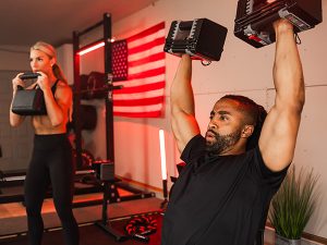 mand and woman lifting PowerBlock dumbbells in a home gym